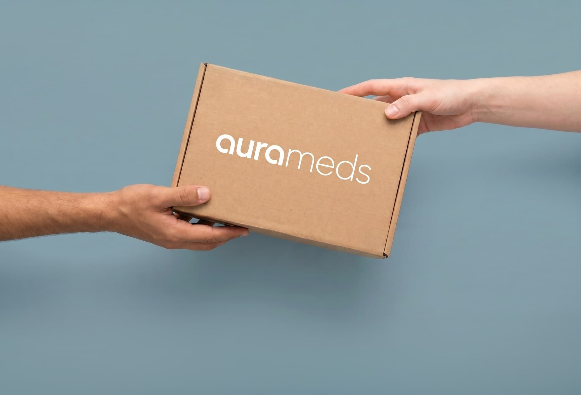 Aura Meds delivery box passed between two hands