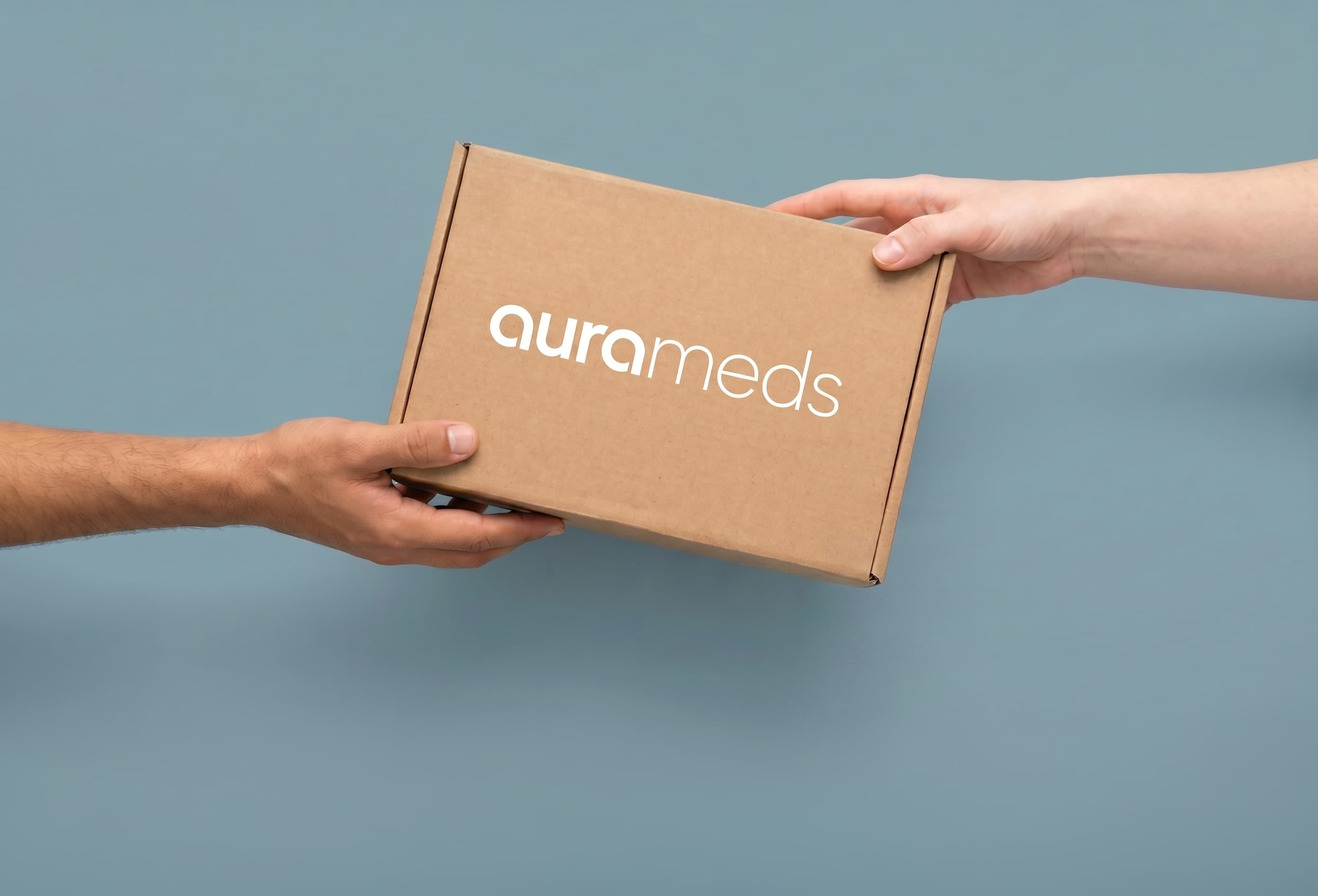 Aurameds delivery box passed between two hands