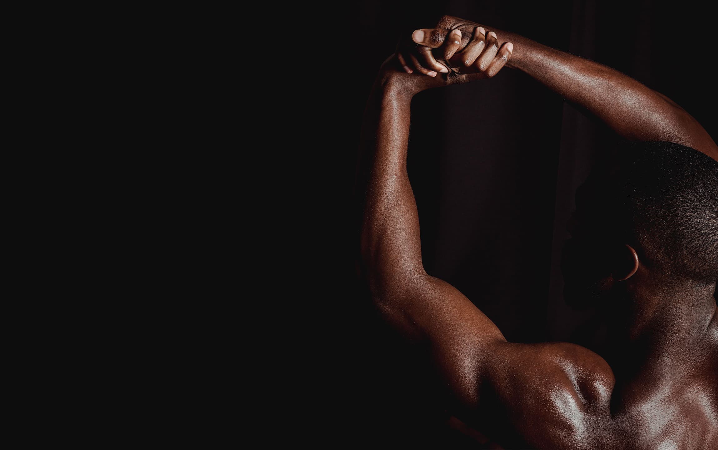 Man stretching his arms in dramatic light